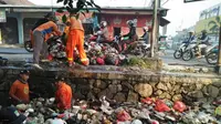 Petugas membersihkan tumpukan sampah kali Abu Bakar Bekasi (Bam Sinulingga/Liputan6.com)