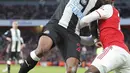 Bek Arsenal, Bukayo Saka berusaha merebut bola pemain Newcastle United, Valentino Lazaro pada pertandingan lanjutan Liga Inggris di Stadion Emirates di London, Minggu, (16/2/2020). Arsenal menang telak 4-0 atas Newcastle. (AP Photo/Frank Augstein)