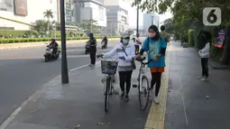 Warga berolahraga menggunakan sepeda di Bunderan HI Jakarta, Minggu (7/6/2020). Aturan itu tertuang dalam pasal 16 ayat 1 mengenai kegiatan sosial budaya.  (Liputan6.com/Herman Zakharia)