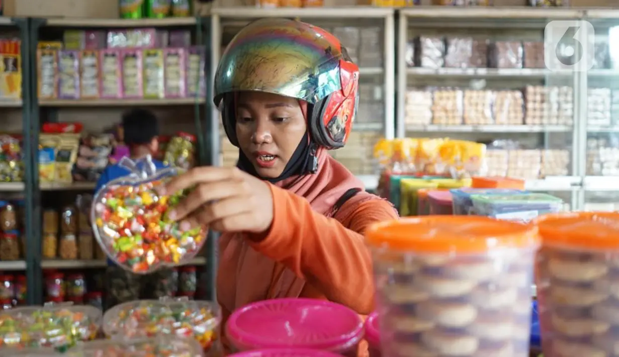 Pembeli melihat dagangan kue kering di salah satu toko penjualan kue kering di kawasan Ciracas, Jakarta, Selasa (19/5/2020). Adanya pandemi covid-19 diakui para pedagang menyebabkan penjualan kue kering menjelang lebaran turun hingga 50 persen. (Liputan6.com/Immanuel Antonius)