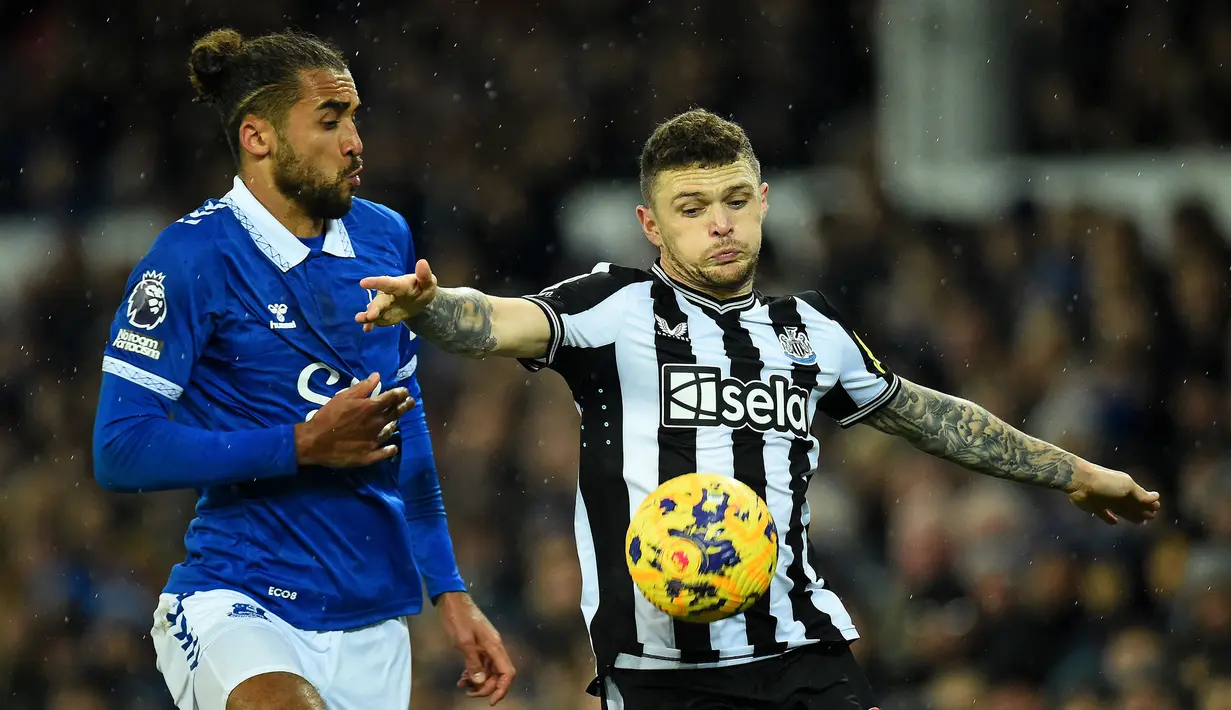 Pemain Newcastle, Kieran Trippier (kanan) berusaha mengontrol bola dibayangi pemain Everton, Dominic Calvert-Lewin pada laga lanjutan Liga Inggris 2023/2024 di Goodison Park, Liverpool, Inggris, Jumat (08/12/2023) dini hari WIB. (AFP/Peter Powell)