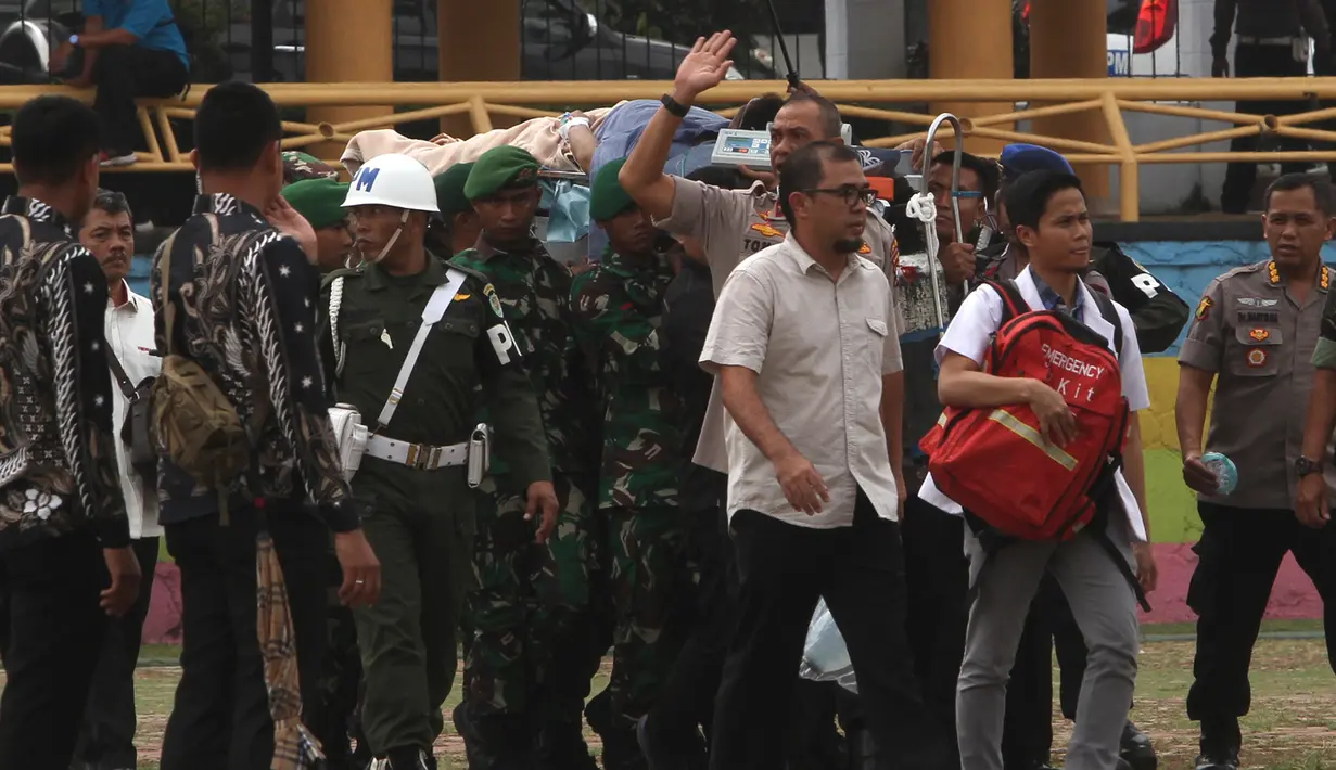 Personel TNI membawa Menko Polhukam Wiranto menggunakan tandu usai diserang orang tak dikenal untuk dievakuasi usai diserang orang tak dikenal di Pandeglang, Banten, Kamis (10/10/2019). Sempat dilarikan ke RS Berkah, Wiranto kini dibawa ke RSPAD Gatot Subroto, Jakarta. (AP Photo/Rafsanjani)