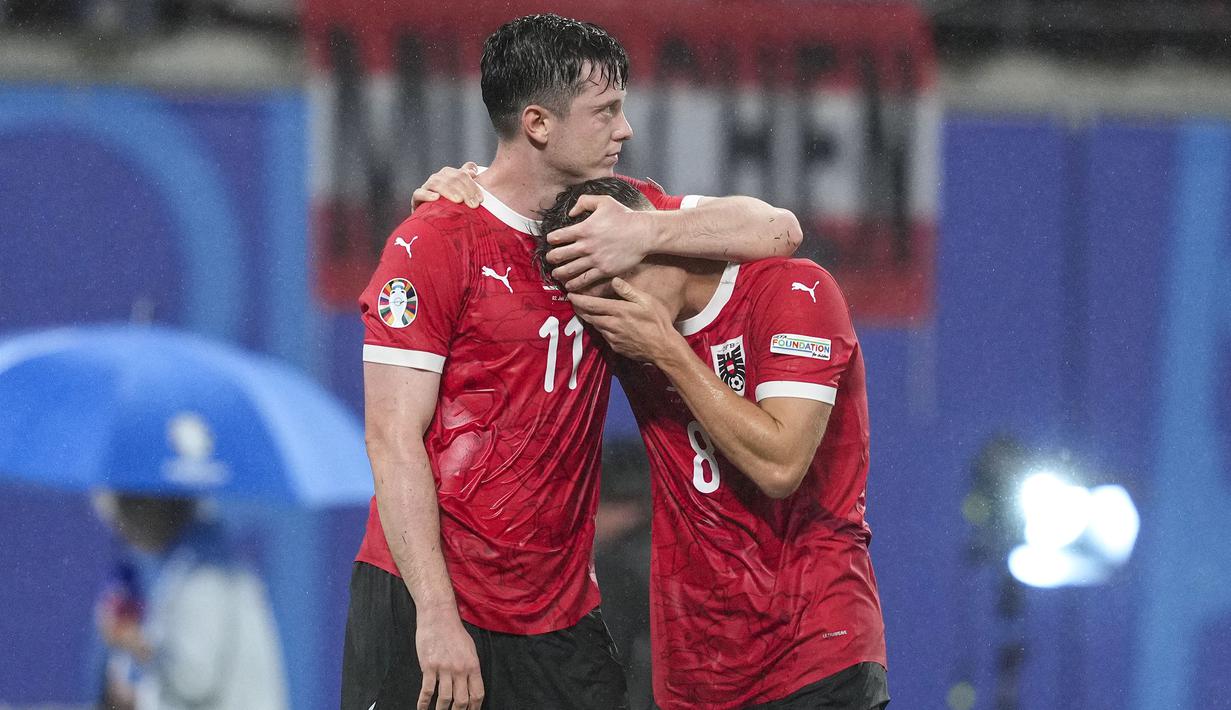 Striker Timnas Austria, Michael Gregoritsch (kiri) berusaha menghibur rekannya, Alexander Prass setelah kalah 1-2 dari Timnas Turki pada laga babak 16 besar Euro 2024 di Red Bull Arena, Leipzig, Jerman, Rabu (3/7/2024). (AP Photo/Andreea Alexandru)