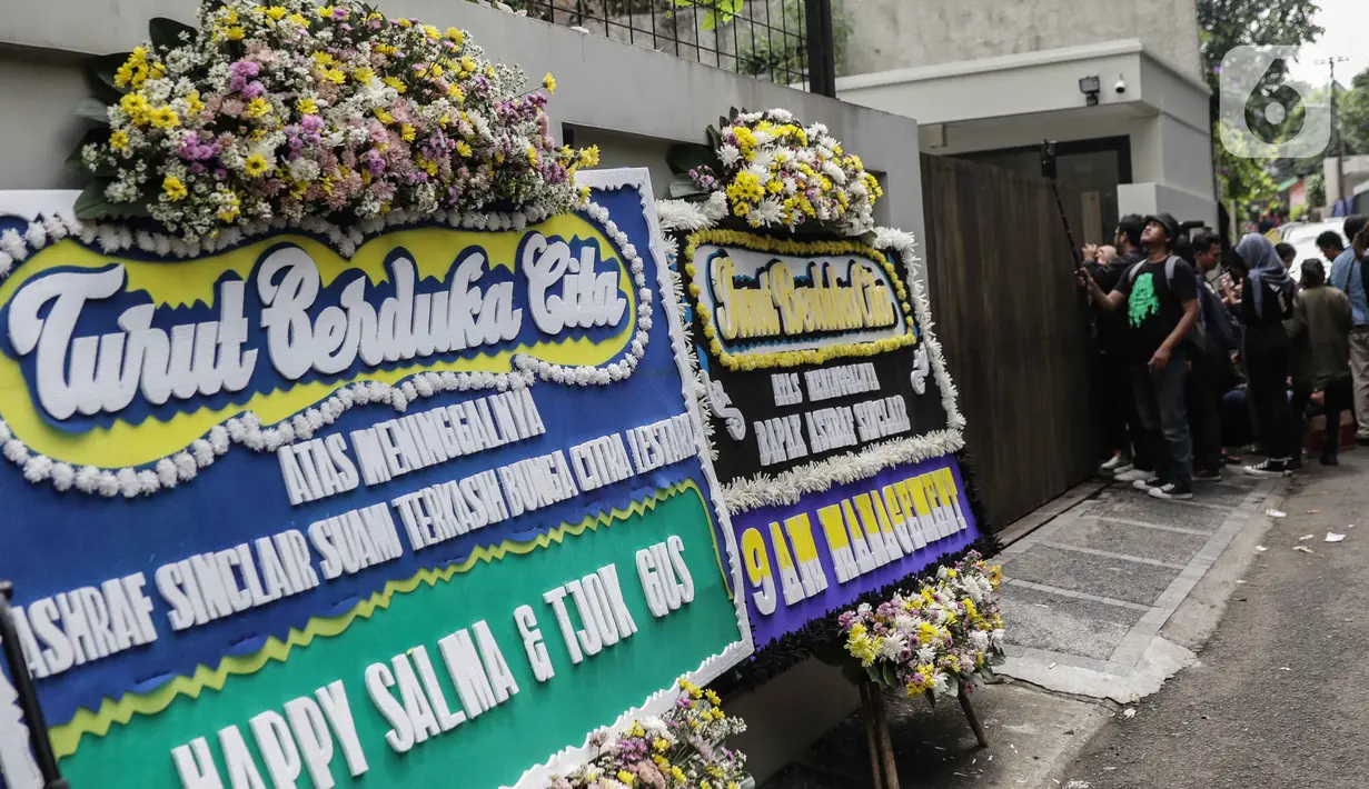 Karangan bunga ucapan duka cita atas meninggalnya almarhum Ashraf Sinclair di kawasan Pejaten Barat IV, Jakarta, Selasa (18/2/2020). Suami Bunga Citra Lestari, Ashraf Sinclair, meninggal dunia diduga akibat serangan jantung pada Selasa 18 Februari 2020 pukul 3.40 pagi. (Liputan6.com/Faizal Fanani)