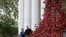 Pajangan karya seni bunga poppy bertajuk 'Weeping Window' dipasang di The Imperial War Museum, London, Kamis (4/10). Bunga buatan itu ditata sedemikian rupa dari ujung atas hingga rerumputan di halamannya. (AP Photo/Kirsty Wigglesworth)