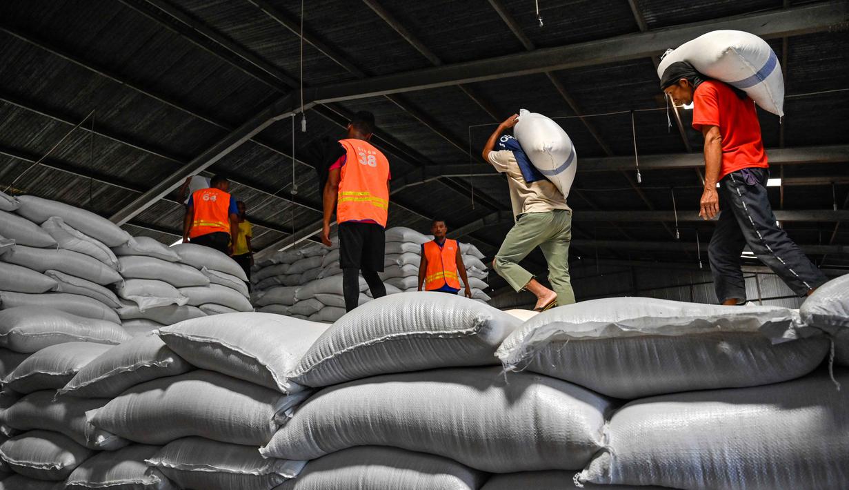 Direktur Utama Perum Bulog, Ahmad Rizal Ramdhani mengatakan bahwa pihaknya telah menyiapkan stok beras yang memadai. Tampak dalam foto, para pekerja merapikan karung-karung beras di gudang Badan Urusan Logistik (Bulog) di Lambaro, Provinsi Aceh pada 29 Desember 2025. (CHAIDEER MAHYUDDIN/AFP)