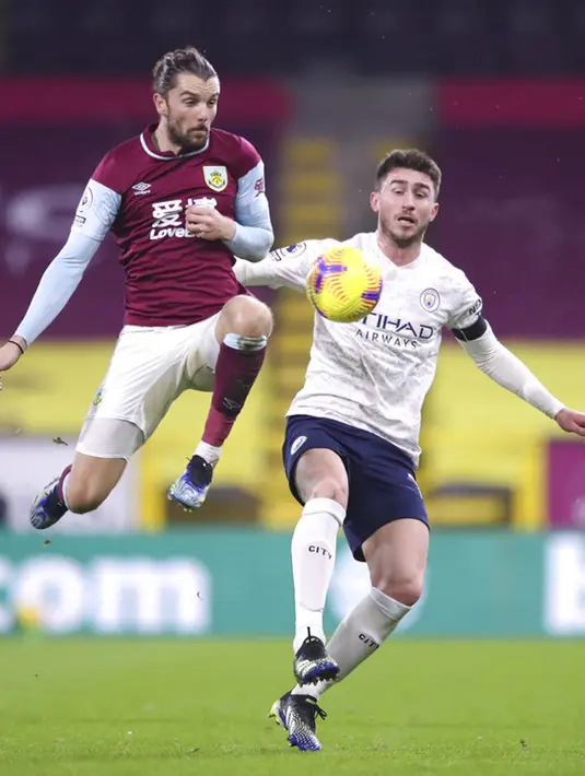 Pemain Burnley Jay Rodriguez (kiri) dan berebut bola dengan pemain Manchester City Aymeric Laporte pada pertandingan Liga Inggris di Stadion Turf Moor, Burnley, Inggris, Rabu (3/2/2021). Manchester City menang 2-0. (Alex Pantling/Pool via AP)