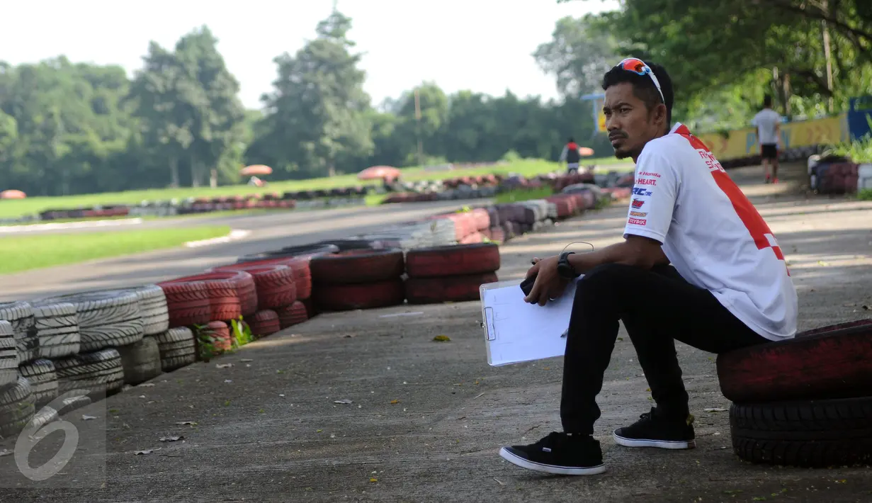 M Fadli Imammudin mengawasi anak didiknya berlatih di Sentul Internasional Karting Sirkuit, Bogor, Rabu (23/2). Sejak 29 maret 2016, ia memutuskan pensiun dan beralih menjadi instruktur astra honda racing team. (Liputan6.com/Helmi Fithriansyah)