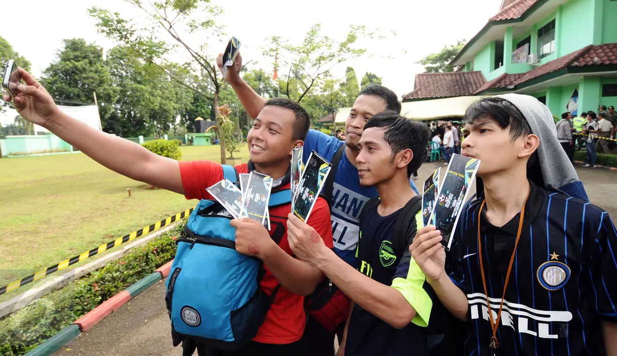 Calon suporter berselfie usai mendapatkan tiket final Piala AFF 2016 di di halaman Kodim 0621 Surya Kancana Kab Bogor, Selasa (13/12). 5000 lembar tiket final antara Indonesia melawan Thailand dijual di Kodim 0621. (Liputan6.com/Helmi Fithriansyah)