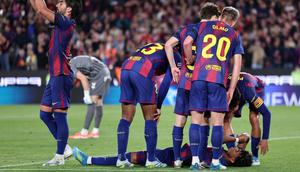 Penyerang Barcelona asal Spanyol bernomor punggung 07, Ferran Torres (kiri), meminta pergantian pemain saat penyerang Barcelona bernomor punggung 10, Lamine Yamal, tergeletak di tanah setelah mengalami cedera selama pertandingan Liga Spanyol antara FC Barcelona dan RC Celta de Vigo di stadion Camp Nou di Barcelona pada 23 April 2026. (Josep LAGO/AFP)