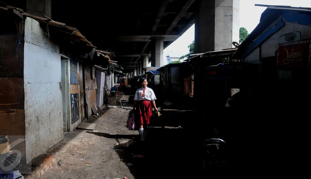 Seorang Pelajar melewati kawasan padat penduduk rumah liar di bawah Tol Pluit (Prof DR Ir Sediyatmo), Jakarta, Selasa (3/1). (Liputan6.com/Gempur M Surya)
