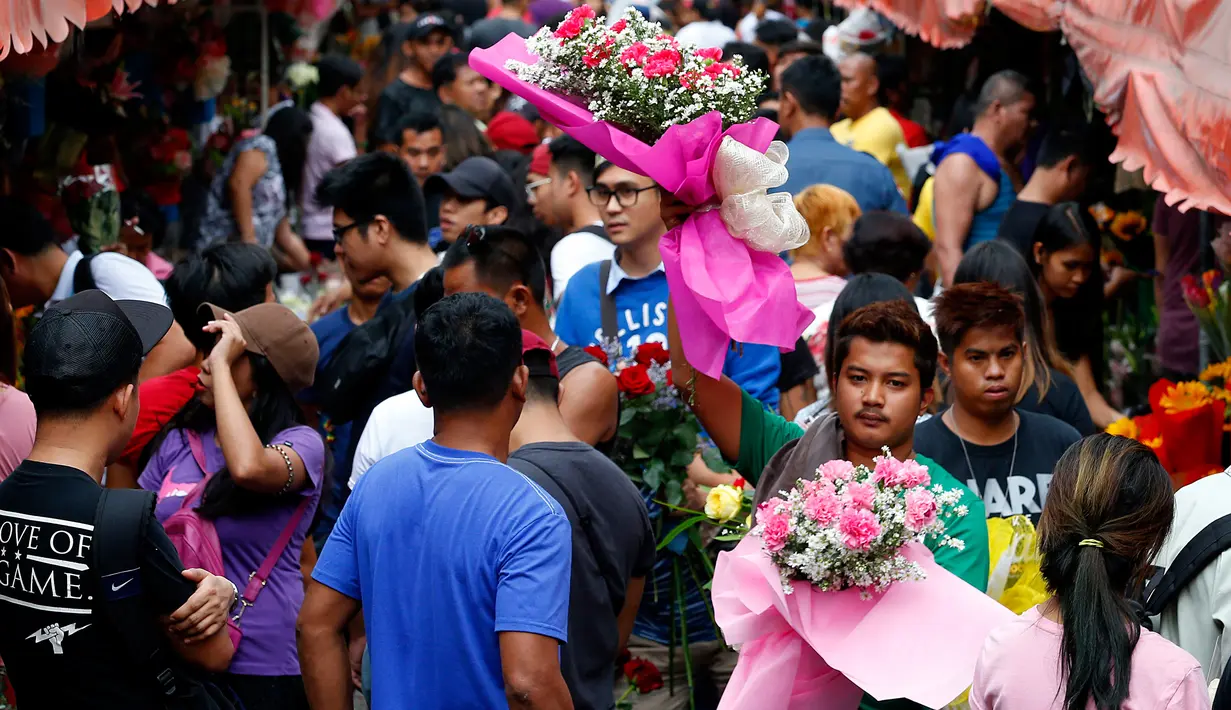 Orang-orang membeli bunga di sebuah pasar bunga sehari sebelum Valentine Day di Manila, Filipina, Rabu (13/2). Sudah tradisi di seluruh dunia, setiap hari valentine identik dengan pemberian bunga atau coklat. (AP Photo/Bullit Marquez)