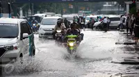 Pelajar yang mengendarai motor menerobos genangan air di kawasan Jalan Merdeka Timur, Jakarta, Selasa (1/11). Hujan deras disertai angin yang mengguyur wilayah Jakarta, mengakibatkan genangan di sejumlah ruas jalan. (Liputan6.com/Faizal Fanani)