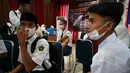 Sejumlah siswa sekolah menengah pertama menunggu untuk menerima dosis vaksin Sinovac pada acara vaksinasi virus corona COVID-19 di Blang Bintang, Provinsi Aceh, 21 September 2021. (CHAIDEER MAHYUDDIN/AFP)
