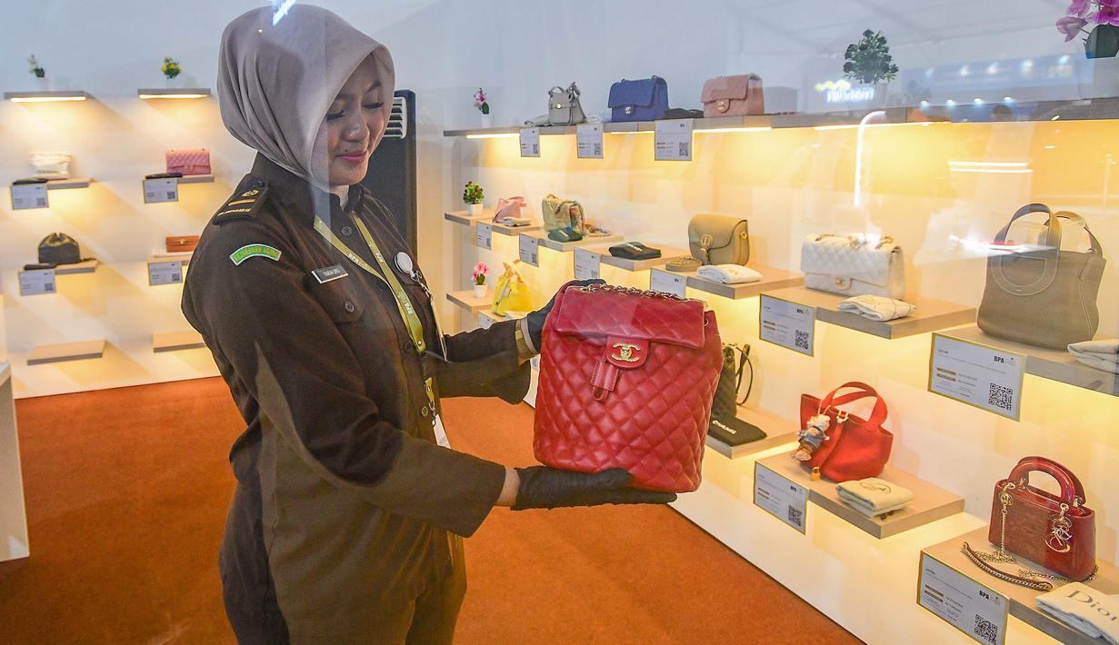 Petugas menunjukkan salah satu tas mewah yang akan dilelang terbuka pada acara Kejaksaan Agung Fair 2026 di Jakarta, Kamis (21/5/2026). (merdeka.com/Arie Basuki)