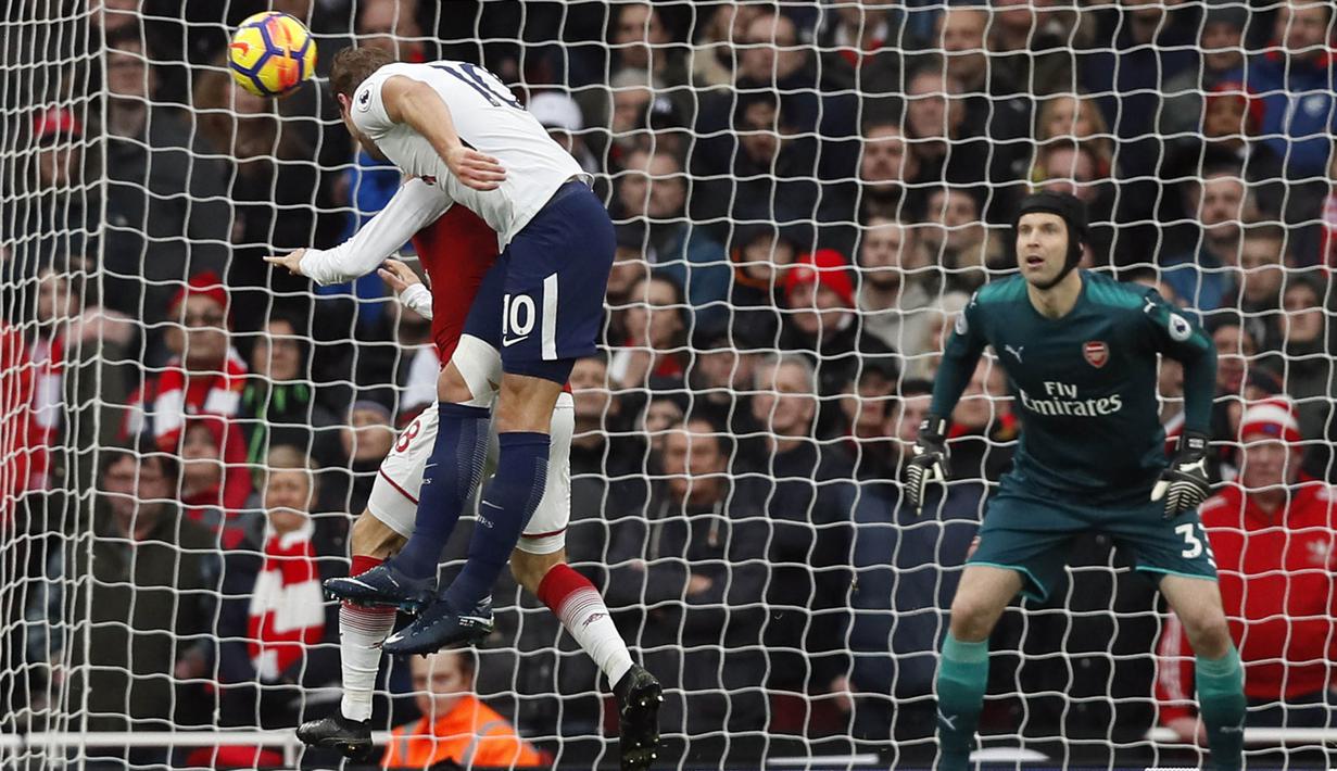 Striker Tottenham, Harry Kane, melepas sundulan ke gawang Arsenal yang dijaga Petr Cech pada laga Premier League di Stadion Emirates, London, Sabtu (18/11/2017). Arsenal menang 2-0 atas Tottenham. (AP/Kirsty Wigglesworth)