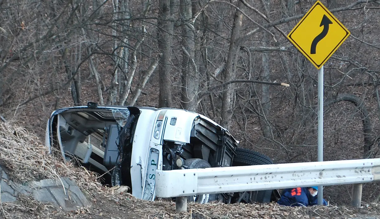 Sejumlah penyidik memeriksa bangkai bus yang tergelincir di Karuizawa, prefektur Nagano, Jepang, Jumat (15/1). Bus yang membawa pengunjung resor ski tersebut tergelincir dan menewaskan 14 orang serta melukai 27 lainnya. (AFP PHOTO/Jiji Press JAPAN OUT)