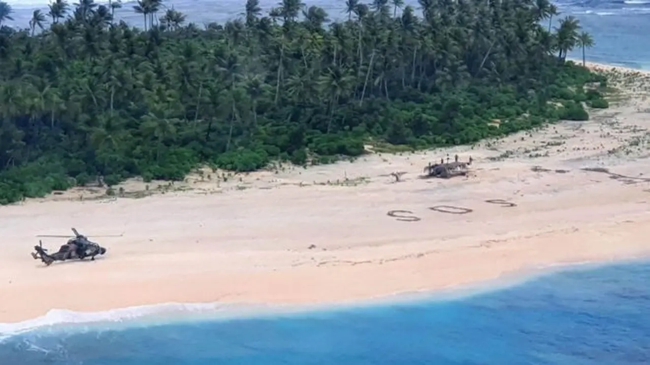 Tiga pelaut menulis pesan SOS di pantai agar diselamatkan. (Australia Government)