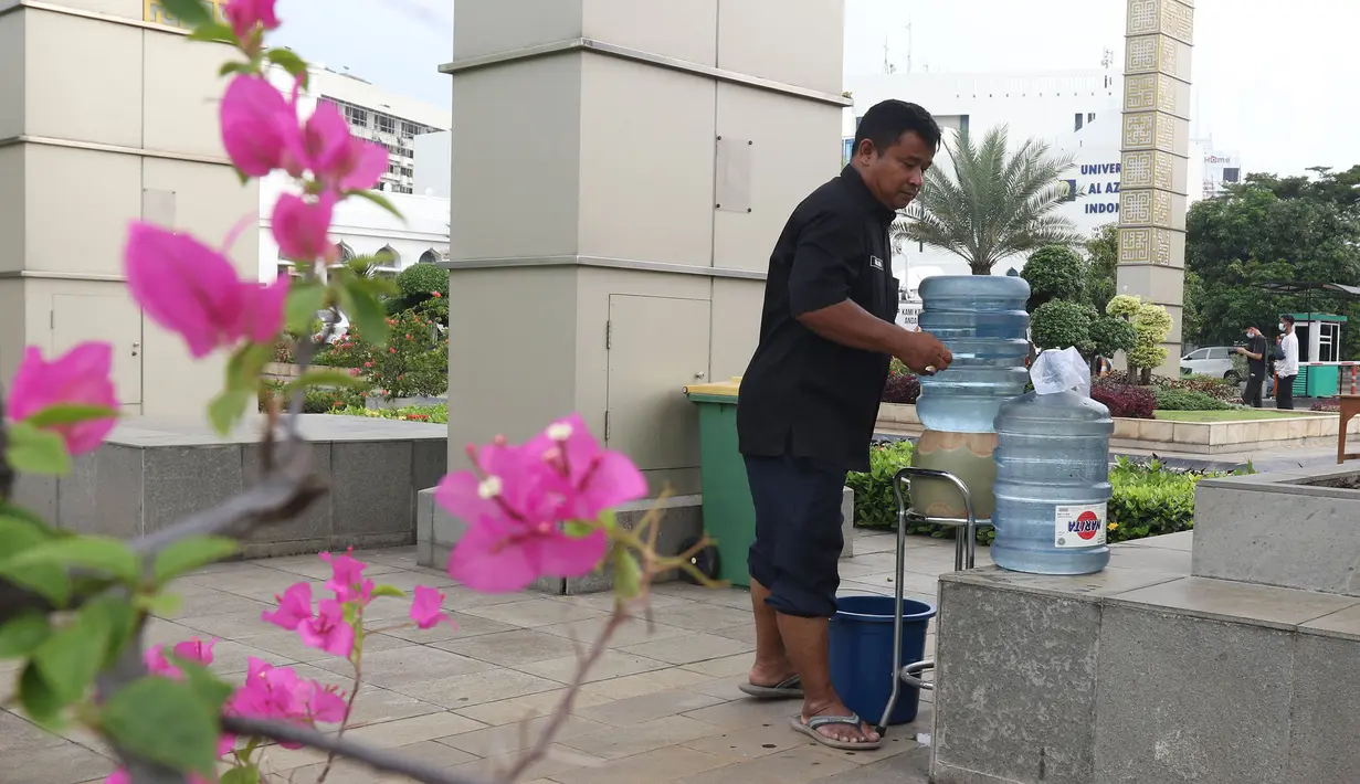 Pekerja menyiapkan air mencuci tangan saat persiapan sholat Idul Fitri di Masjid Al Azhar, Jakarta, Rabu (11/5/2021). Masjid Al Azhar akan menggelar sholat idul Fitri secara berjamaah di lapangan masjid tersebut dengan protokol pencegahan COVID-19 yang ketat. (Liputan6.com/Herman Zakharia)
