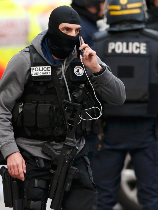 Seorang pria ditangkap oleh petugas keamanan Perancis selama operasi di Saint - Denis, Paris, Perancis, Rabu (18/11/2015). Sedikitnya lima orang ditahan dan diintrogasi oleh polisi Perancis.  (REUTERS/Christian Hartmann)