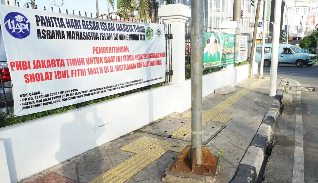 Spanduk pemberitahuan peniadaan salat id terpasang di Jalan Matraman Raya, Jakarta, Minggu (24/5/2020). Adanya pandemi Covid-19 menyebabkan kegiatan salat id 1441 H di lokasi tersebut ditiadakan. (Liputan6.com/Immanuel Antonius)
