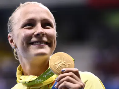 Perenang Swedia Sarah Sjostrom berpose di podium dengan medali emas renang nomor 100 meter gaya kupu-kupu yang diraihnya pada Olimpiade 2016 di Rio de Janeiro, Minggu (7/8). Sjostrom memecahkan rekor dunianya atas namanya sendiri (AFP PHOTO/Martin BUREAU)