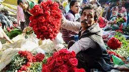 Aktivitas pedangang bunga mawar di pasar bunga grosir di Kolkata, India (7/2). Jelang perayaan hari Valentine, bunga mawar banyak diburu dari tanggal 7 Februari dengan ditandai dengan Rose Day. (AFP Photo/Dibyangshu Sarkar)