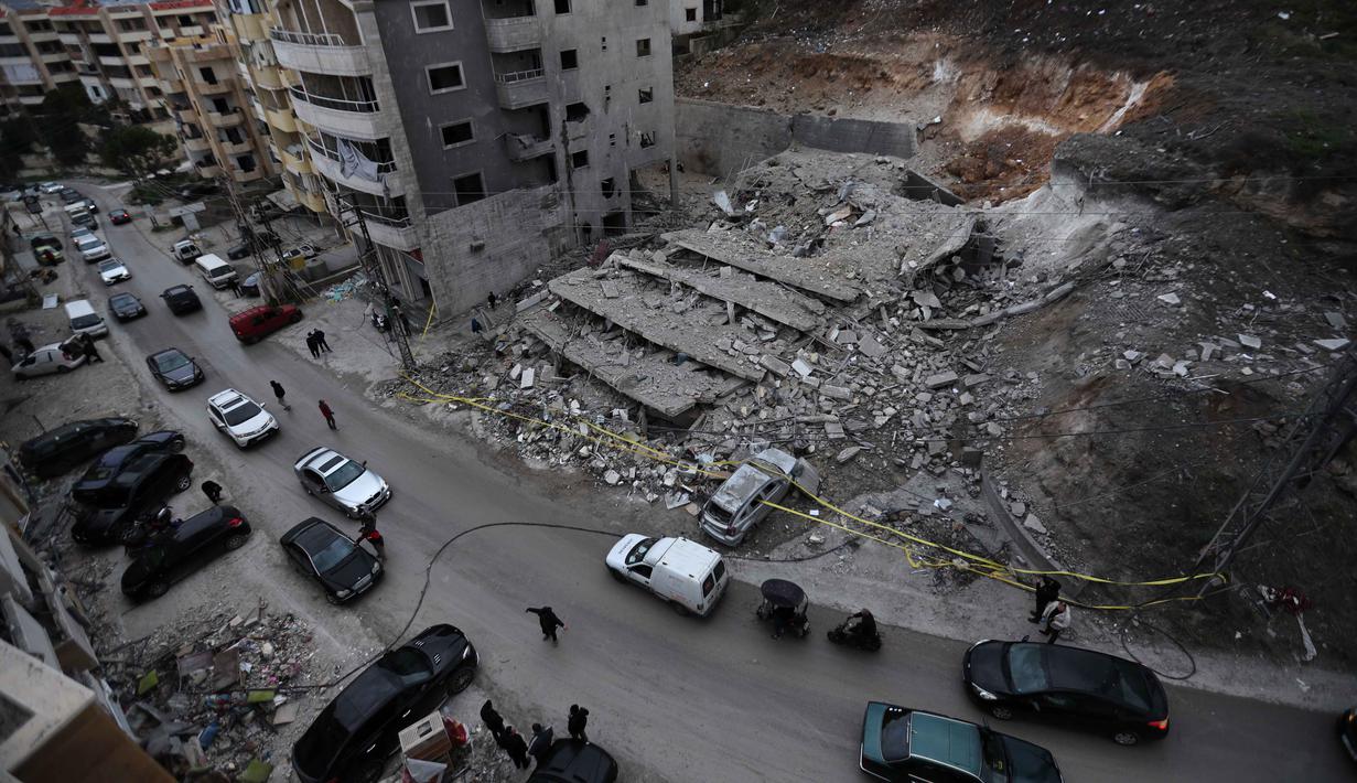 Militer Lebanon mengecam serangan Israel terhadap rumah warga sipil sebagai pelanggaran kedaulatan dan kesepakatan gencatan senjata. Tampak dalam foto, orang-orang melewati sebuah bangunan yang hancur akibat serangan Israel di desa Qennarit, Lebanon selatan, Kamis 22 Januari 2026. (AP Photo/Mohammed Zaatari)