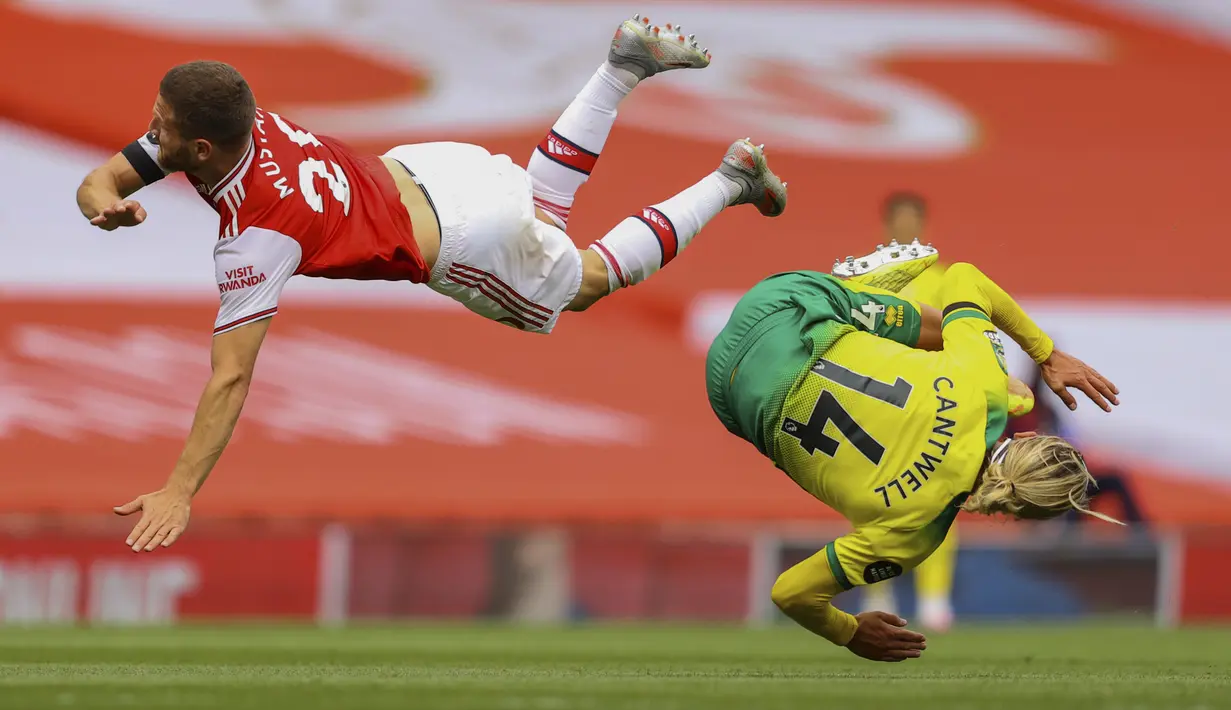 Pemain Norwich City Todd Cantwell (kanan) dan pemain Arsenal Shkodran Mustafi berbenturan pada pertandingan Premier League di Emirates Stadium, London, Inggris, Rabu  (1/7/2020). Arsenal menang 4-0 lewat gol Pierre-Emerick Aubameyang, Granit Xhaka, dan Cedric Soares. (Richard Heathcote/Pool via AP)