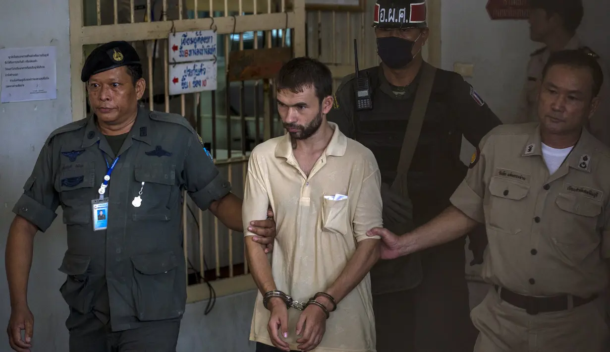 Petugas menggiring tersangka yang masih terlihat tegang usai diadili Pengadilan Bangkok, Sabtu (5/9/2015). Tim forensik gagal menemukan kaitan pemboman Bangkok dengan dua pelaku serangan mematikan di Kuil Erawan, Thailand. (REUTERS/Athit Perawongmetha)
