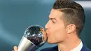 Cristiano Ronaldo mencium trofi penghargaan Pemain Terbaik Dunia FIFA 2016 pada acara Best FIFA Football Awards di Zurich, Senin (9/1). Gelar ini melengkapi kesuksesan Ronaldo yang memperoleh Ballon d'Or 2016. (Ennio Leanza/Keystone via AP)