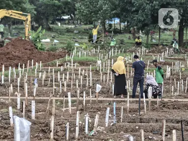 Warga berziarah ke makam kerabat di kompleks pemakaman protokol Covid-19, TPU Bambu Apus, Jakarta, Selasa (2/3/2021). TPU Bambu Apus kini tidak lagi menampung pemakaman jenazah protokol Covid-19 akibat lahan di dua blok sudah penuh dan dialihkan ke TPU Srengseng Sawah. (merdeka.com/Iqbal S Nugroho)