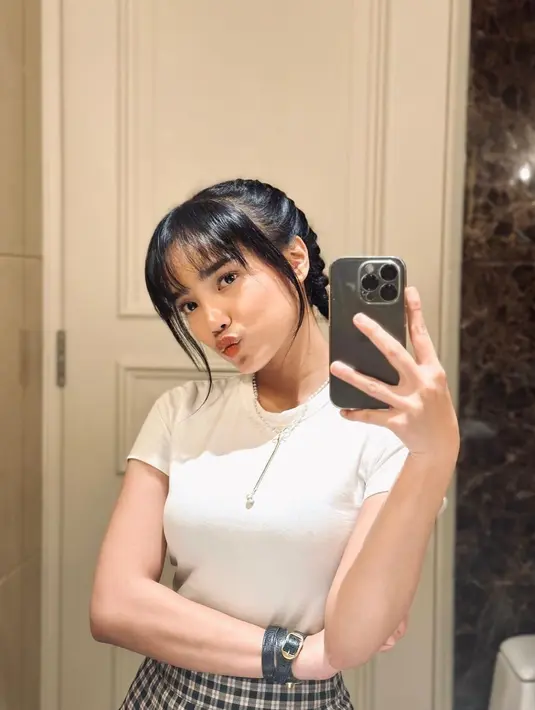 Atau atasan kaus putih lengan pendek juga bisa dipadu padankan dengan rok mini bermotif kotak-kotak seperti terlihat pada Fuji di foto ini. Foto: Instagram.