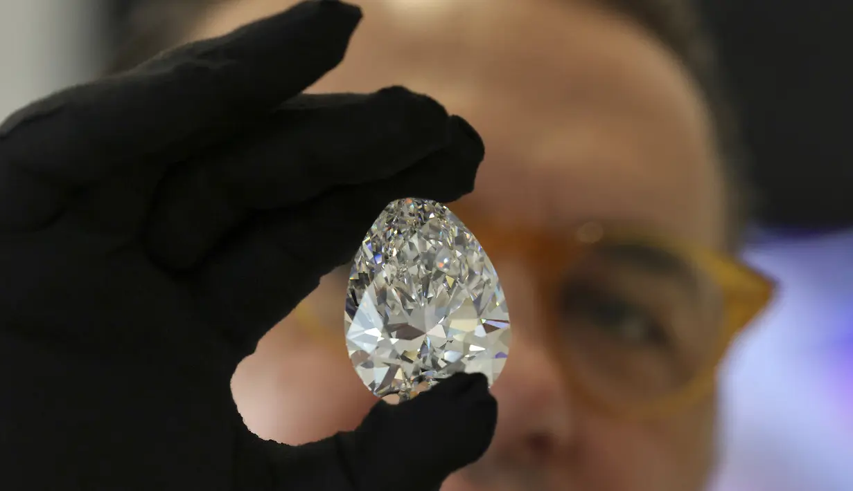 Seorang petugas rumah lelang Christie memperlihatkan sebuah berlian raksasa yang dijuluki "The Rock" kepada media di Dubai, Jumat (25/3/202). Berlian tersebut dipamerkan menjelang pelelangan yang diperkirakan akan terjual hingga USD30 juta atau sekitar Rp430 miliar. (Karim SAHIB/AFP)
