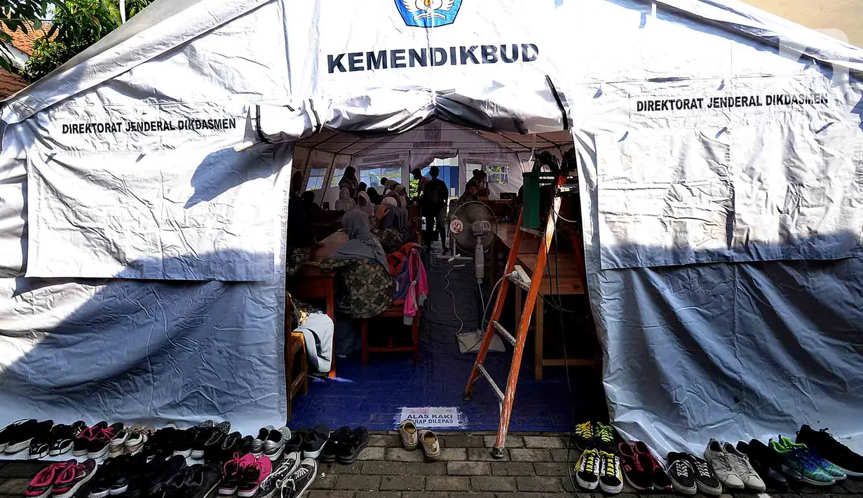 Murid SMP dan SMA Sekolah Khusus Assalam 01 melaksanakan ujian di tenda darurat halaman SKh Assalam 02, Ciater, Serpong, Tangerang Selatan, Selasa (3/12/2019). Sebanyak 84 murid penyandang tunarungu, tunawicara, dan tunagrahita terpaksa mengikuti ujian di tenda darutat. (merdeka.com/Arie Basuki)