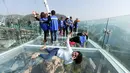 Pengunjung berselfie di atas panggung berlantai kaca yang berada di pinggir tebing di Shilinxia, Beijing, 30 april 2016. Panggung kaca yang menggantung hingga 32.8 meter dari tepi tebing ini merupakan objek wisata baru di China. (AFP PHOTO/STR)
