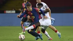 Pemain Barcelona, Gavi (tengah kiri) berusaha melewati penjagaan pemain Sevilla, Albert-Mboyo Sambi Lokonga pada laga lanjutan Liga Spanyol 2024/2025 yang berlangsung di Estadi Olimpic Lluis Companys, Barcelona, Spanyol, Senin (21/10/2024) dini hari WIB. (AFP/Josep Lago)