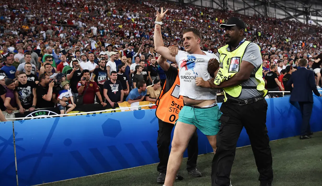 4. Fans Rusia diamankan petugas karena melakukan penyerangan ke arah pendukung Inggris pada laga Grup B di Stade Velodrome, Marseille. Kerusuhan antara kedua belah suporter kembali berlanjut di luar stadion. (AFP/Bertrand Langlois)