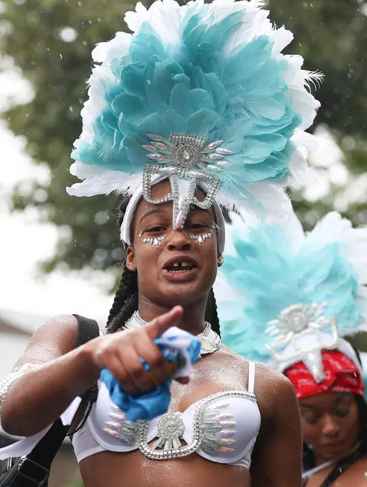 Seorang penari ambil bagian pada parade hari pertama Karnaval Notting Hill di London barat, Minggu (26/8). Ratusan ribu orang tumplek ke jalan menikmati warna-warni dan musik yang tak berhenti dimainkan. (AFP/Daniel LEAL-OLIVAS)