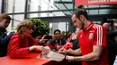 Gareth Bale memberikan tanda tangannya kepada fans saat menggelar konferensi pers jelang babak 8 besar Piala Eropa 2016, Stadium COSEC, Prancis, Rabu (29/6). Bale menyebut kini Wales sudah berada setingkat di atas Inggris. (REUTERS / Gonzalo Fuentes)