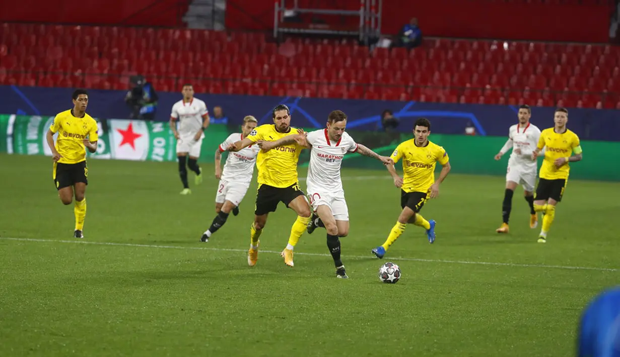 Pemain Sevilla Ivan Rakitic (tengah) menggiring bola melewati para pemain Borussia Dortmund pada leg pertama babak 16 besar Liga Champions di Stadion Ramon Sanchez Pizjuan, Seville, Spanyol, Rabu (17/2/2021). Borussia Dortmund menang 3-2. (AP Photo/Angel Fernandez)