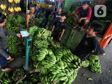 Pedagang tengah menurunkan pisang yang akan di jual di Pasar Lembang, Kota Tangerang, Kamis (28/3/2024). (Liputan6.com/Angga Yuniar)