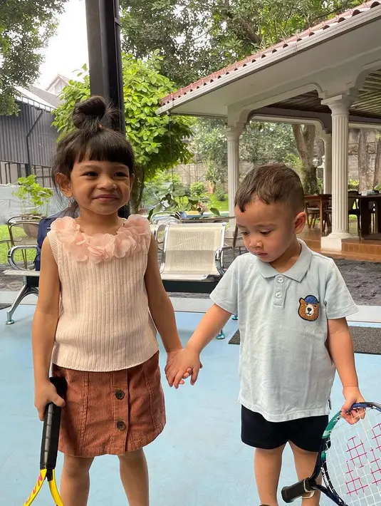 Sementara itu, Rayyanza terlihat mengenakan polo shirt biru dengan gambar kepala beruang dipadukan celana pendeknya. [@riniperdiyanti]