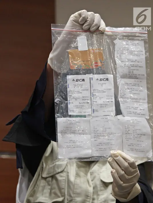 Penyidik KPK menunjukkan barang bukti struk ATM dalam OTT Bupati Ngada Marianus Sae di Gedung KPK, Jakarta, Senin (12/2). Akibat ditangkap KPK, Marianus Sae tak menghadiri penetapan calon Pilkada NTT. (Liputan6.com/Herman Zakharia)