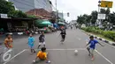 Sejumlah anak bermain sepak bola di Jalan Tambak, Manggarai, Jakarta, Jumat (22/7). Minimnya lahan bermain, sejumlah anak manfaatkan jalanan untuk bermain. (Liputan6.com/Yoppy Renato)