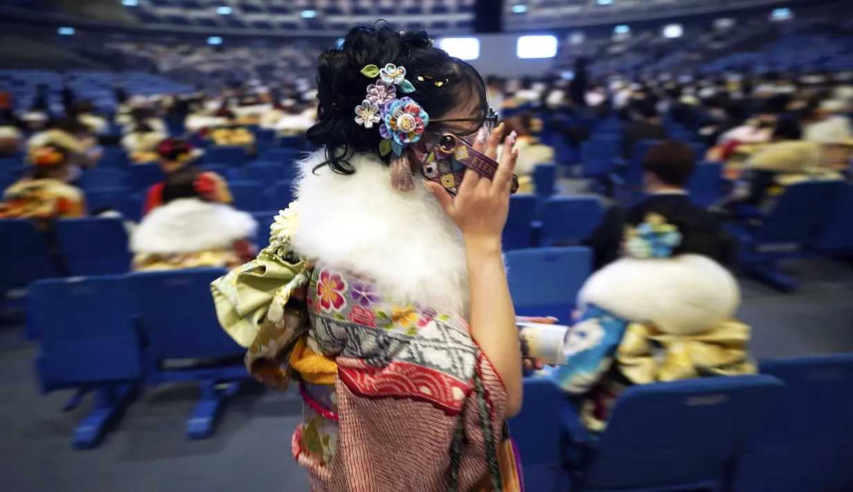Seorang perempuan Jepang berkimono yang merayakan ulang tahun ke-20 berjalan sebelum memulai upacara resmi, yang biasa disebut upacara Kedewasaan di Yokohama dekat Tokyo, Senin (9/1/2023). Diadakan setiap tahun pada hari Senin kedua di bulan Januari, pemerintah kota setempat merayakan Hari Kedewasaan atau Seiji no Hi. (AP Photo/Eugene Hoshiko)