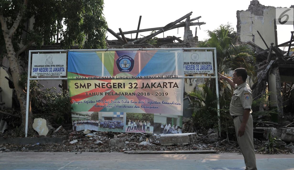 Seorang petugas menunjukkan kondisi bangunan yang ambruk di SMP Negeri 32, Pejagalan, Tambora, Jakarta, Selasa (14/8). Hingga saat ini Pemprov DKI Jakarta belum juga merenovasi ulang bangunan sekolah tersebut. (Merdeka.com/ Iqbal S. Nugroho)