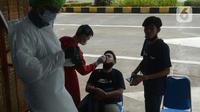 Petugas melakukan swab test antigen kepada pemudik saat arus balik Lebaran di Terminal Pulogebang, Jakarta, Jumat (21/5/2021). Pada hari ini, ada tiga pemudik terindikasi positif COVID-19. (merdeka.com/Imam Buhori)