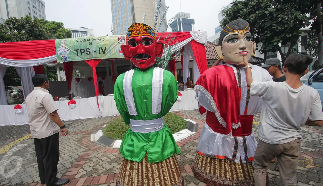 Pekerja memasang ondel-ondel di TPS 4 Kelurahan Gambir, Jalan Tanah Abang Timur, Jakarta, Selasa (18/4). Nantinya Presiden Joko Widodo akan melaksanakan pencoblosan hak suaranya pada Pilkada DKI 2017 di TPS tersebut. (Liputan6.com/Faizal Fanani)