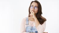 Seorang perempuan berkacamata sedang berpikir (Foto Dok: Freepik/cookie_studio).